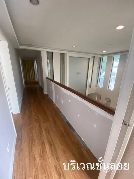 店屋 出租在Watthana, Bangkok - 楼道带木质扶手，俯瞰挑高空间与高窗。