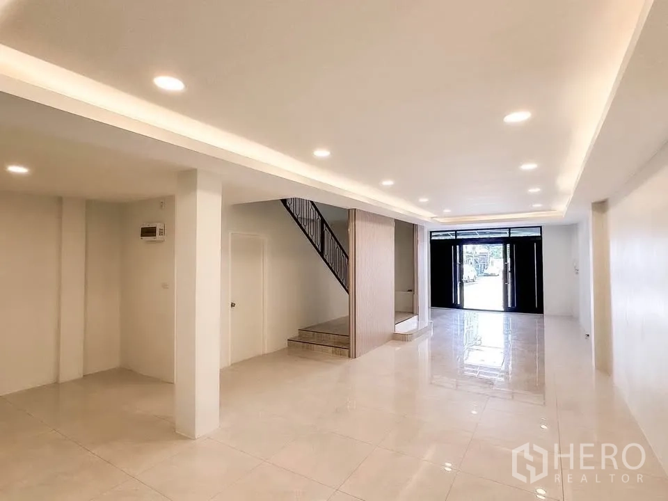 联排别墅 for sale in Wang Thonglang, Bangkok - 一层开放空间，筒灯天花与前部入口门。