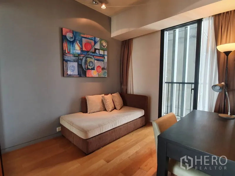 公寓 出租在Sathon, Bangkok - 书房或客房，日间床、书桌及通往阳台的落地门。