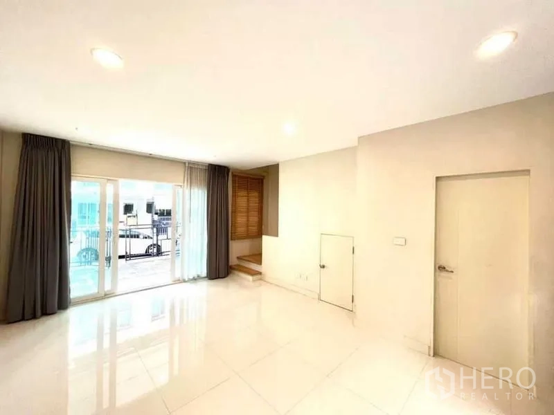 ทาวน์เฮาส์ ขายในBang Kapi, Bangkok - ห้องนั่งเล่นชั้นล่าง ประตูกระจกบานเลื่อนสู่ชานบ้าน พร้อมห้องเก็บของใต้บันได