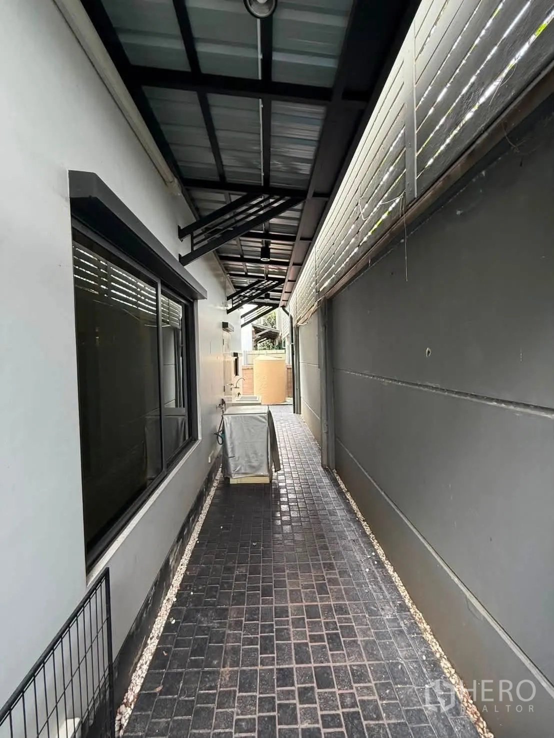 独栋房屋 for rent in Bang Kapi, Bangkok - 屋侧有遮雨顶的通道与黑色铺砖地面。