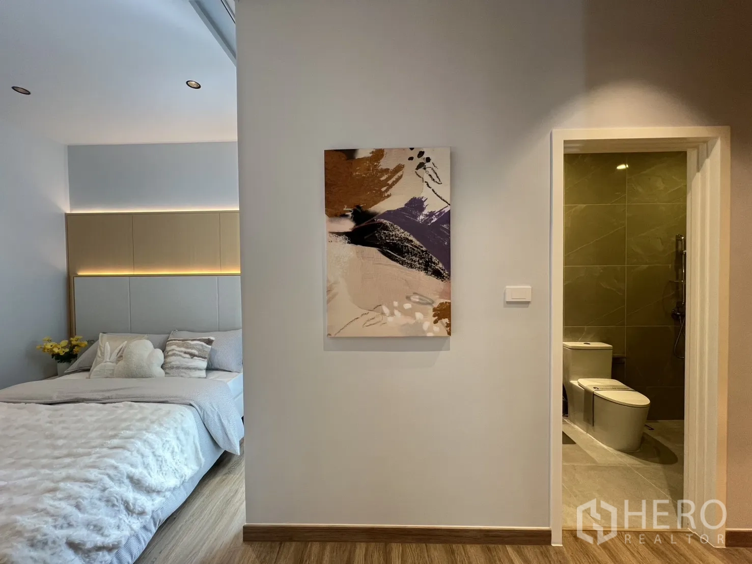 Townhouse for rent in Mueang Samut Prakan, Samut Prakan - Bedroom corner with doorway to en-suite bathroom lined in gray tiles.