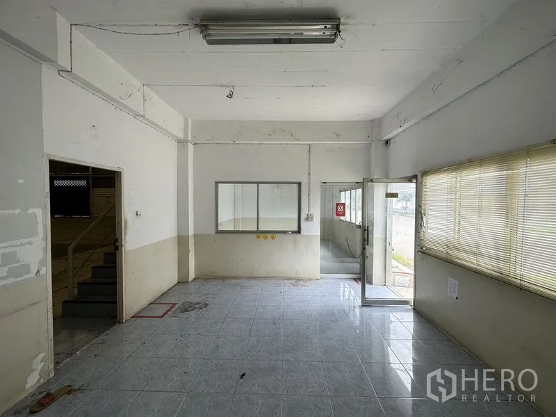 工厂 出租在Phra Nakhon Si Ayutthaya - 一层办公室/接待区，地砖、大窗与玻璃入户门。