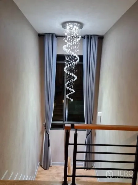 บ้าน ให้เช่าหรือขายในSaphan Sung, Bangkok - บันไดบ้านพร้อมโคมระย้าลำดับเกลียวและผ้าม่านยาว