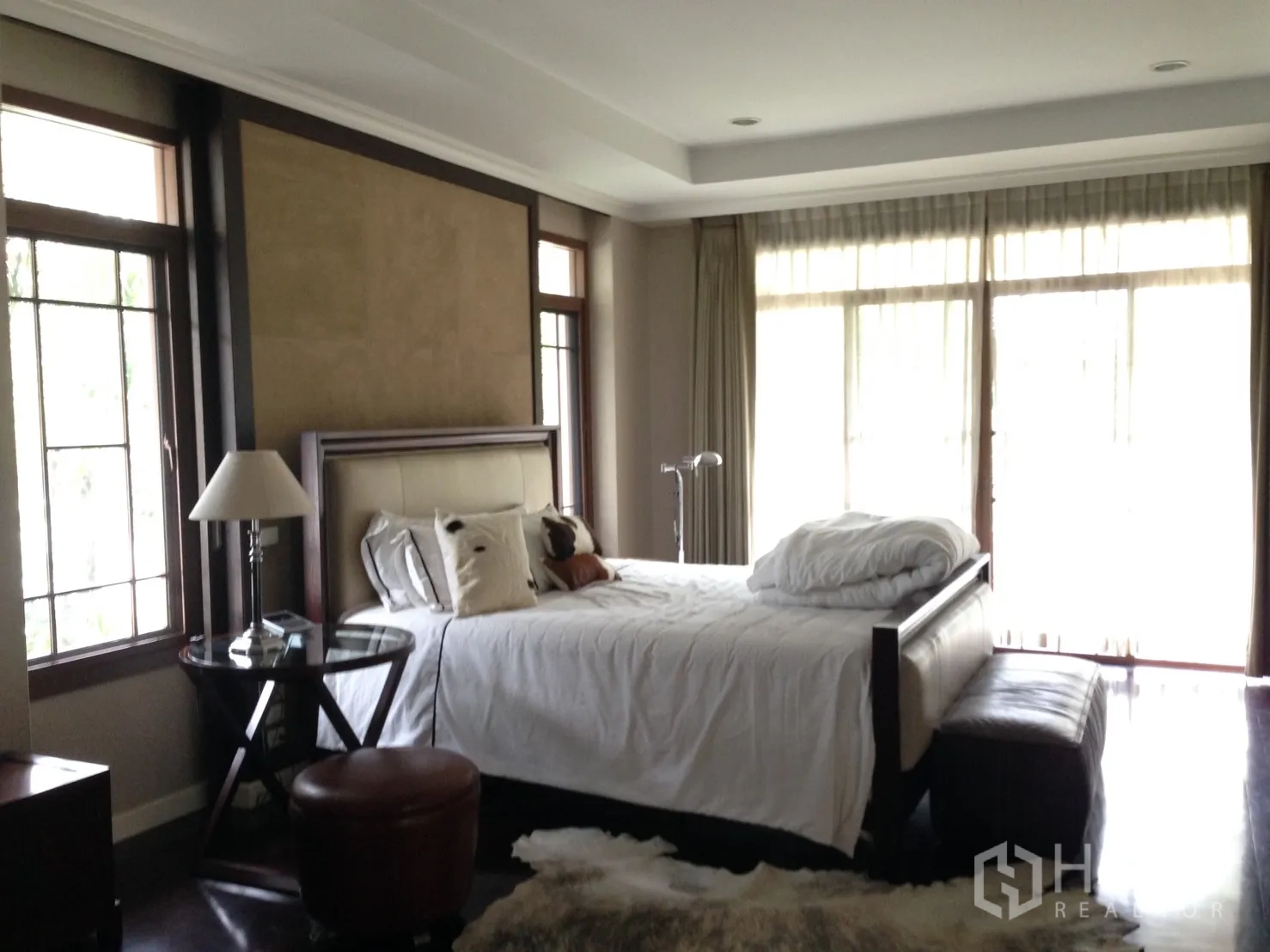 Detached House for rent or sale in Suan Luang, Bangkok - Master bedroom with large windows, sheer curtains and upholstered bed.