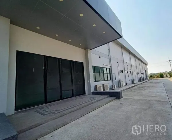 货栈 出租或出售在Pathum Thani - 带雨棚的装卸入口与建筑侧立面，配宽大硬化场地。