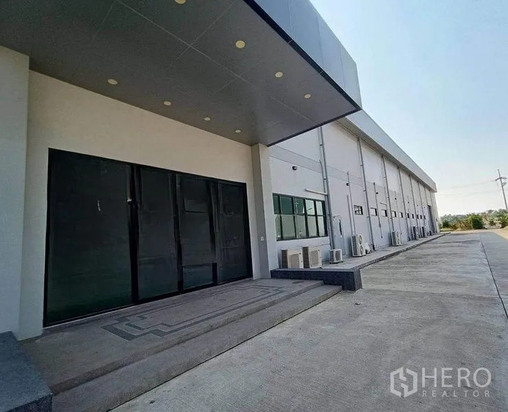 货栈 出租或出售在Pathum Thani - 带雨棚的装卸入口与建筑侧立面，配宽大硬化场地。