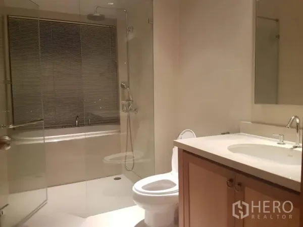 คอนโด ให้เช่าหรือขายในKhlong Toei, Bangkok - ห้องน้ำสมัยใหม่พร้อมตู้กระจกกั้นอาบน้ำเหนืออ่างอาบน้ำ เคาน์เตอร์อ่างล้างหน้า และโทนสีอบอุ่น