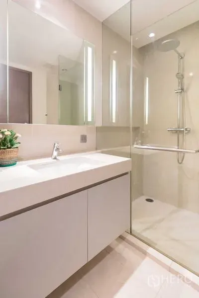 Condominium for rent - Modern bathroom with a large vanity and a glass-enclosed rain shower.