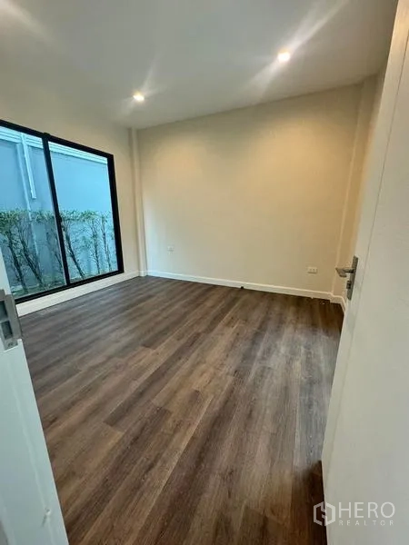 Detached House for rent or sale - Ground-floor bedroom with big window and yard access, wood flooring.