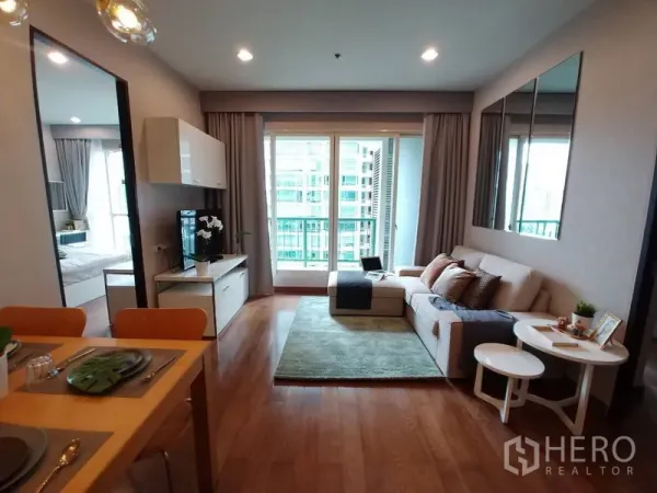 คอนโด ให้เช่าในPathum Wan, Bangkok - ห้องนั่งเล่นสว่าง โซฟา พื้นไม้ ประตูระเบียงกระจกสูง มองวิวเมือง