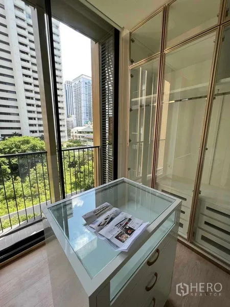 คอนโด ให้เช่าในWatthana, Bangkok - ห้องแต่งตัวแบบวอล์กอิน ตู้เสื้อผ้ากระจกและไอส์แลนด์ หน้าต่างสูงเต็มผนังเห็นวิวต้นไม้และเมือง