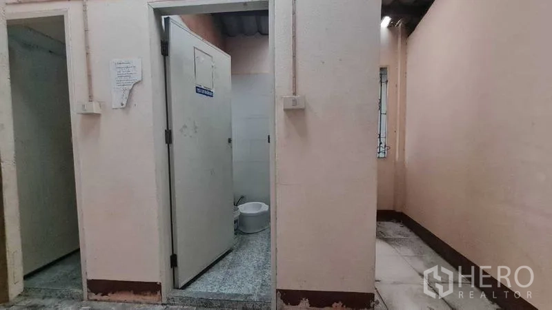 Shophouse for sale in Watthana, Bangkok - Simple bathroom area with separate toilet cubicles and tiled surfaces.