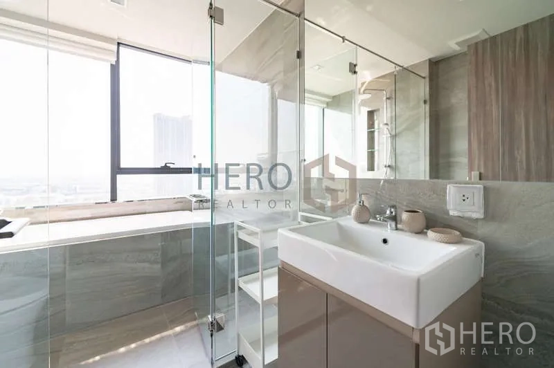 คอนโด ให้เช่า - ห้องน้ำพร้อมอ่างล้างหน้า ตู้ชาวเวอร์กระจก และอ่างอาบน้ำติดหน้าต่างรับแสงธรรมชาติ