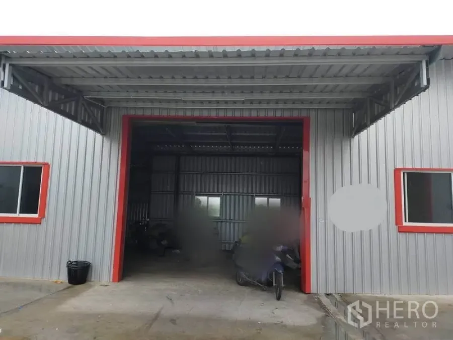 คลังสินค้า ให้เช่าในBang Yai, Nonthaburi - โกดังผนังเมทัลชีท ด้านหน้าเป็นหลังคาคลุมลานขนถ่ายสินค้า กรอบสีแดงและมีหน้าต่าง