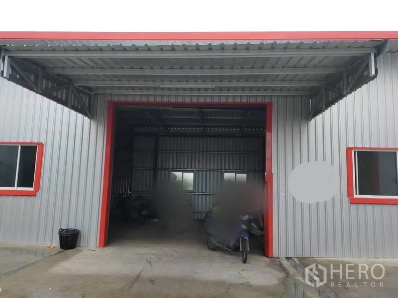 คลังสินค้า ให้เช่าในBang Yai, Nonthaburi - โกดังผนังเมทัลชีท ด้านหน้าเป็นหลังคาคลุมลานขนถ่ายสินค้า กรอบสีแดงและมีหน้าต่าง