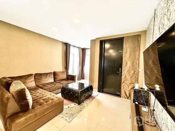 Detached House for sale in Bang Phli, Samut Prakan - Cozy living room featuring an L-shaped sofa, TV wall and glossy floor tiles.