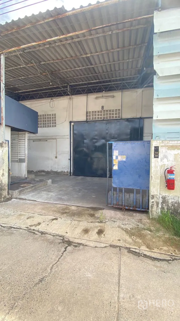 Factory for rent in Bang Phli, Samut Prakan - Front view of factory entrance with roof canopy and sliding steel door.
