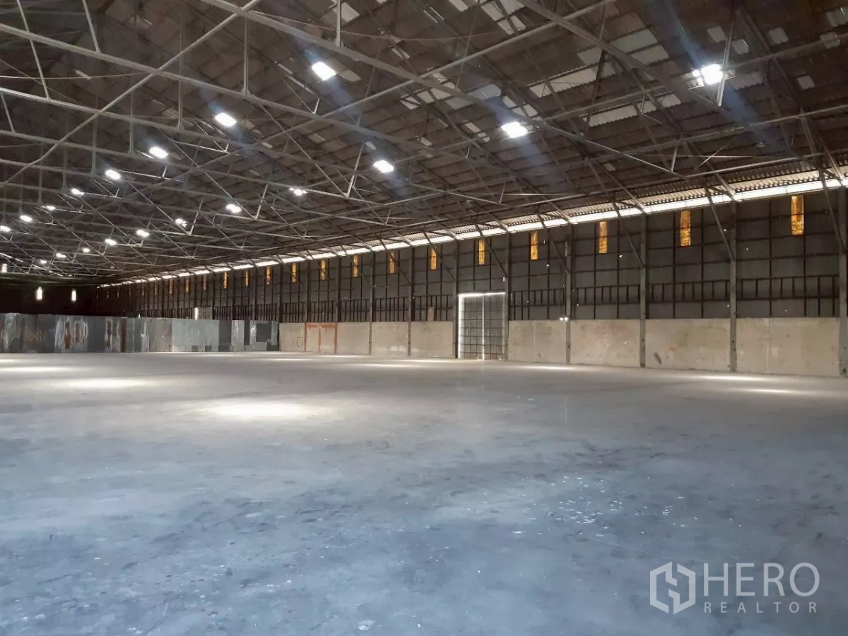 Warehouse for rent in Pak Kret, Nonthaburi - Open-plan warehouse with roof skylights, steel beams and expansive floor area for logistics or storage.