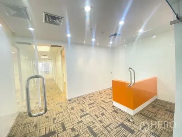 办公空间 出租在Chatuchak, Bangkok - 玻璃门后接待区，橙色前台与嵌灯照明