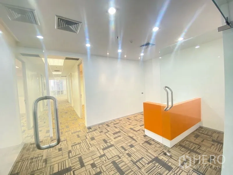 办公空间 出租在Chatuchak, Bangkok - 玻璃门后接待区，橙色前台与嵌灯照明