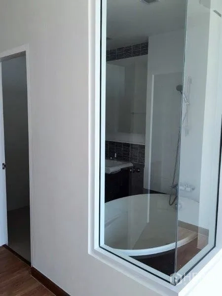 公寓 出售在Bang Na, Bangkok - 玻璃隔断浴室，配圆形浸泡浴缸与手持花洒。