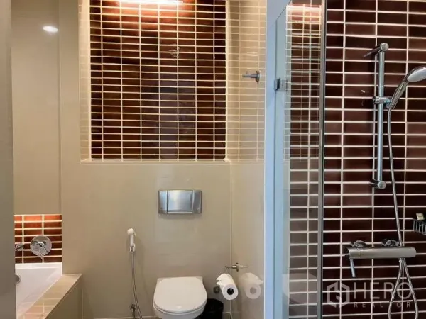 Condominium for rent in Bang Kho Laem, Bangkok - Modern bathroom with glass shower, bathtub edge, and brown subway tiles.