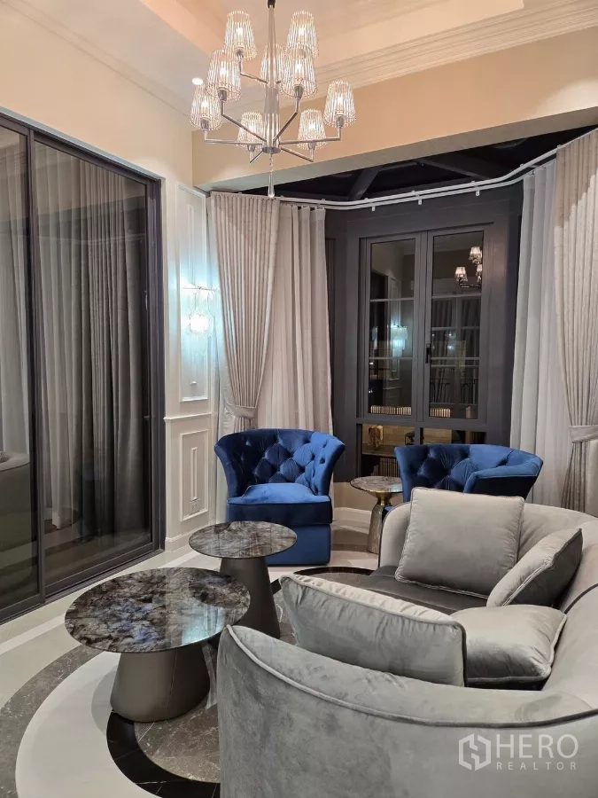 Detached House for rent or sale in Bang Kapi, Bangkok - Cozy bay-window sitting room with blue velvet armchairs and round marble coffee tables.
