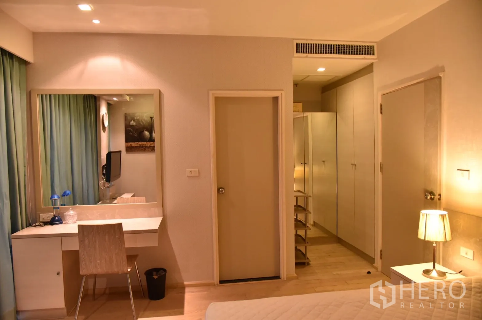 Condominium for rent or sale in Khlong Toei, Bangkok - Bedroom vanity and dressing area with mirror, built-in wardrobes and soft lighting.