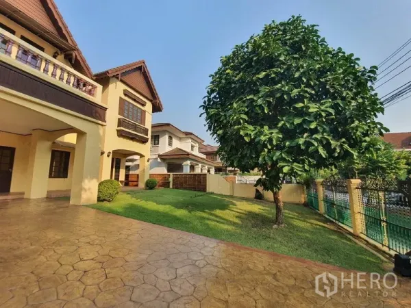 Detached House for rent - Front garden with a large shade tree, green lawn and fenced boundary.