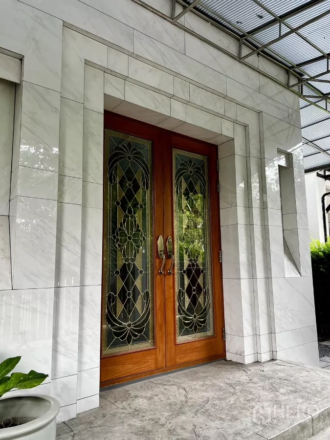 Detached House for rent or sale in Prawet, Bangkok - Elegant double wooden front door with stained glass set in a marble-clad entryway.