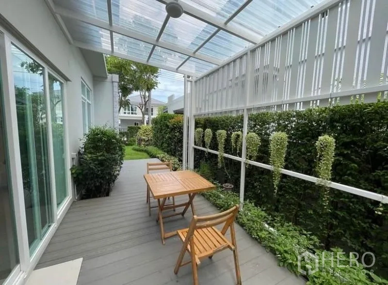 บ้าน ให้เช่าในPrawet, Bangkok - เฉลียงหลังคาใสที่มองเห็นสวนจัดแต่ง รั้วพุ่มไม้ และชุดโต๊ะเก้าอี้กลางแจ้ง