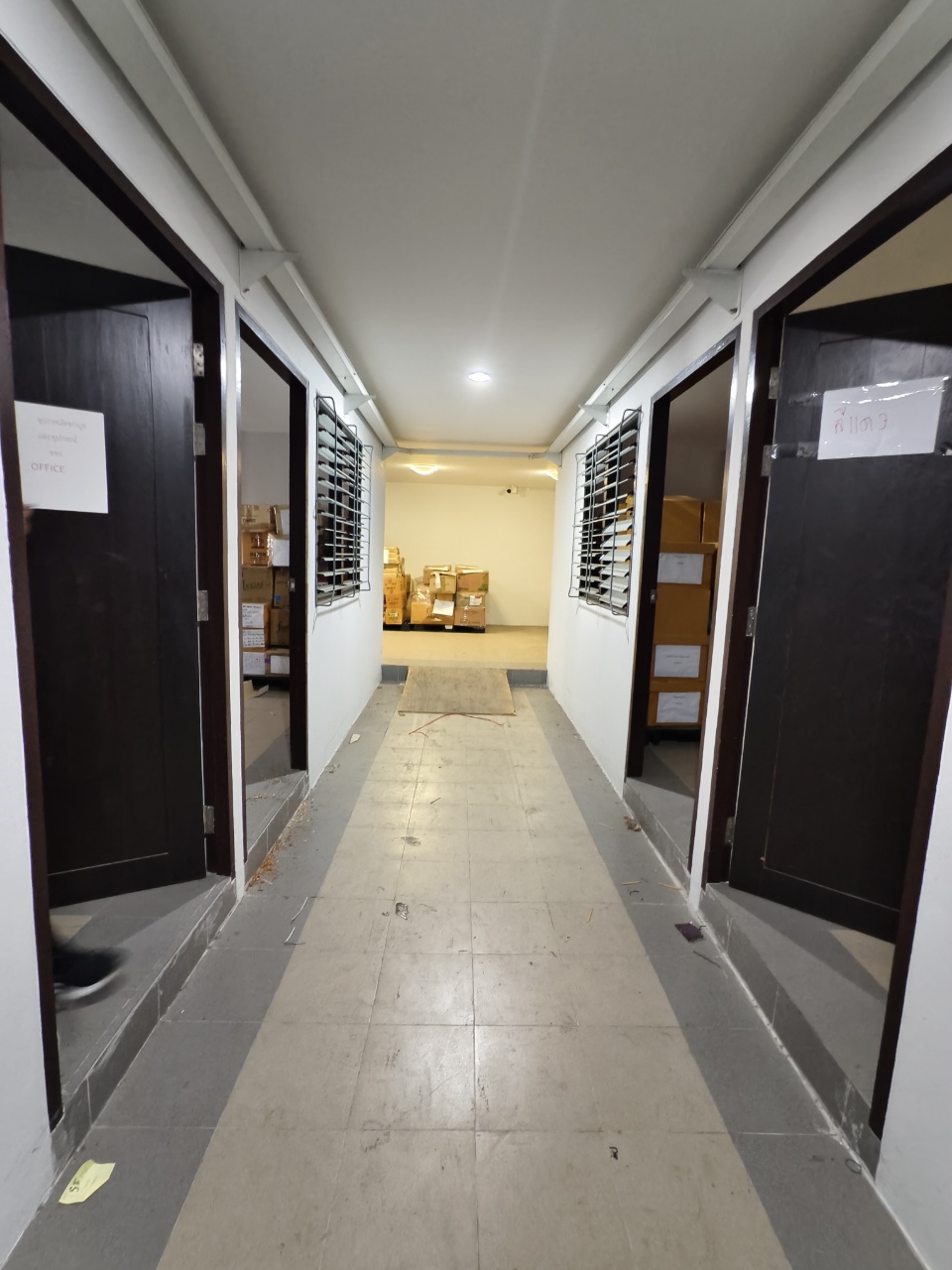 Warehouse for rent in Lat Krabang, Bangkok - Interior corridor with multiple office doors and louvered windows leading to storage rooms.