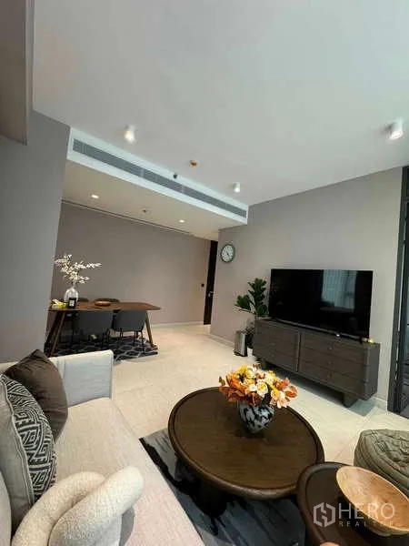 公寓 出租在Bang Rak, Bangkok - 开放式客厅，沙发、电视柜与相连餐区