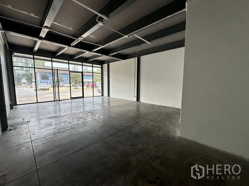 Office Space for rent in Khlong Toei, Bangkok - Spacious 59 sqm office unit with floor-to-ceiling windows, white partition walls and sliding glass door.