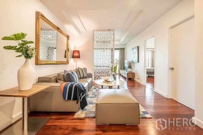 คอนโด ให้เช่าหรือขายในKhlong San, Bangkok - อีกมุมของห้องนั่งเล่น แสดงโซฟา โคมไฟ และโถงทางเดินไปยังห้องนอน