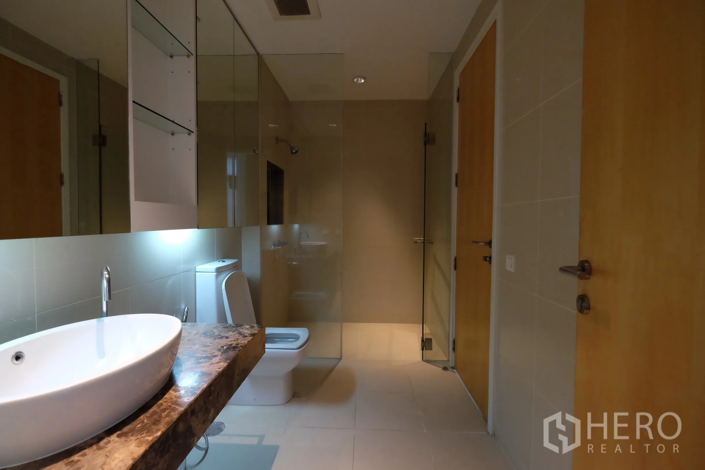 公寓 出租在Bang Rak, Bangkok - 现代卫浴，石材台面台上盆、坐便器与玻璃淋浴间。