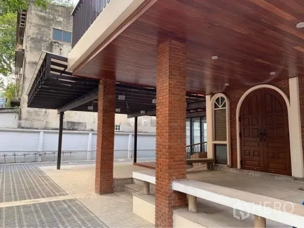 Detached House for rent in Ratchathewi, Bangkok - Covered porch and carport with brick pillars and a grand arched wooden front door.