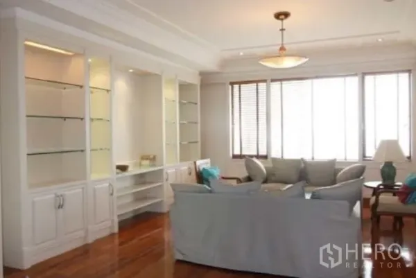 公寓 出租在Sathon, Bangkok - 采光充足的起居区，落地窗、实木地板、吊灯与玻璃展示柜。