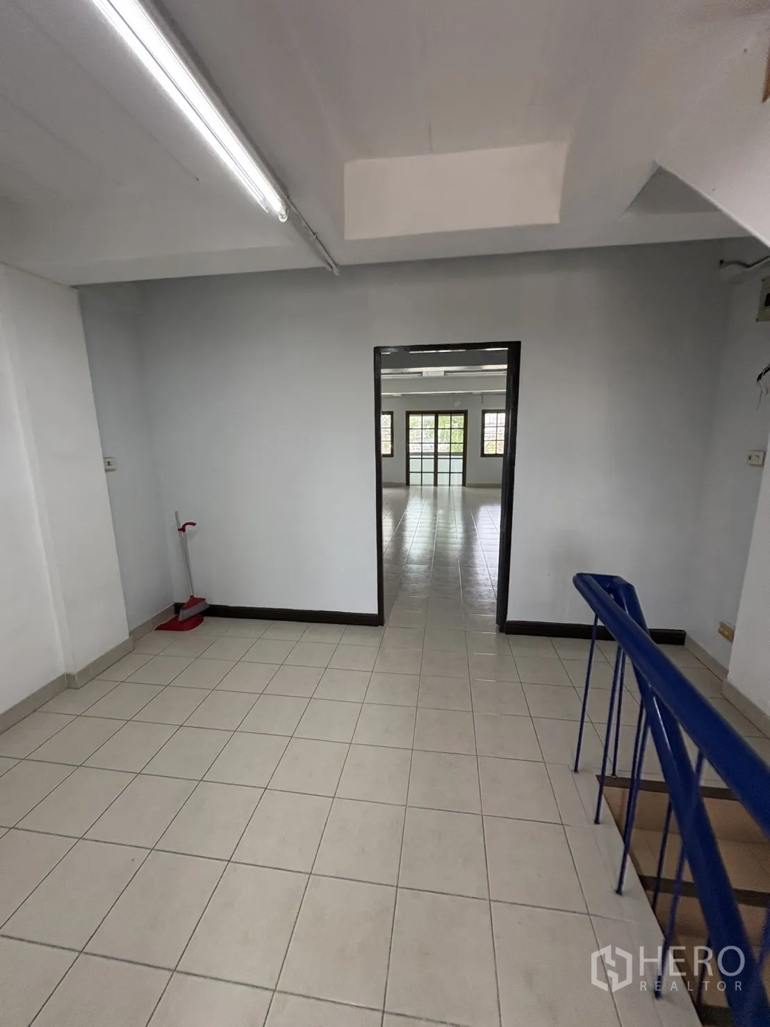 店屋 出租在Phra Khanong, Bangkok - 带蓝色扶手的楼梯平台，连接明亮的办公区域。