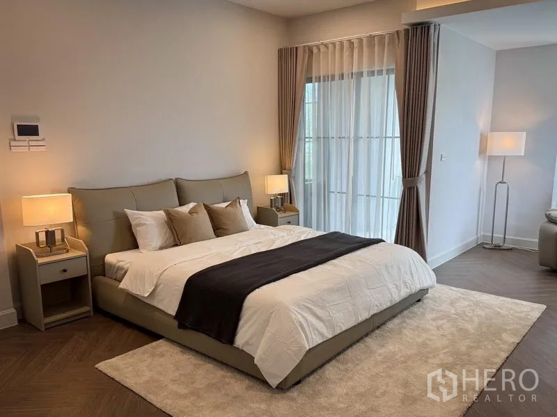 独立式住宅 出租或出售 - 主套房配特大床、床头灯与连通休息区。