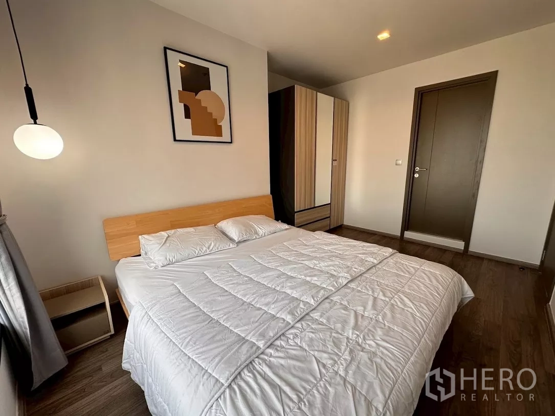 Condominium for rent in Chatuchak, Bangkok - Bedroom view showing bed, wardrobe and minimalist artwork.