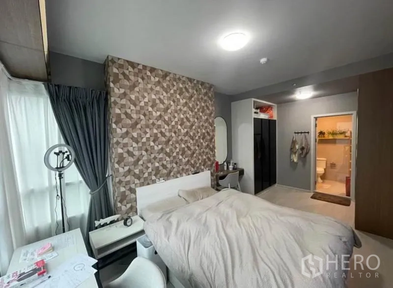 Condominium for sale in Bang Sue, Bangkok - Bedroom with geometric feature wall, vanity and access to bathroom.
