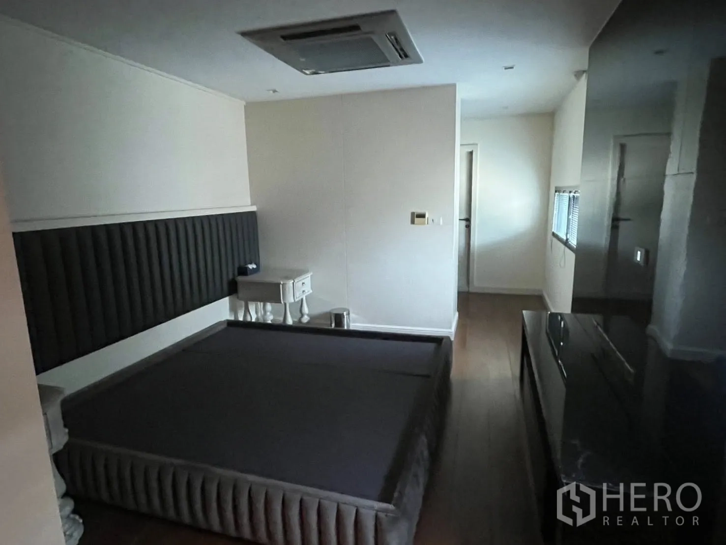 Home Office for rent in Watthana, Bangkok - Bedroom with built-in headboard, bed frame, and wood flooring.