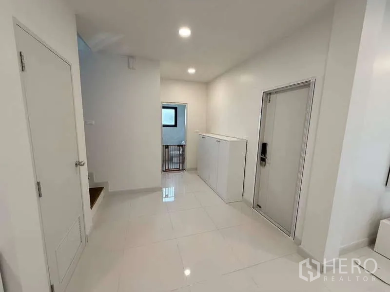 Detached House for sale in Bang Phli, Samut Prakan - Ground-floor hallway with storage cabinet, bright tiles and access to stairs.