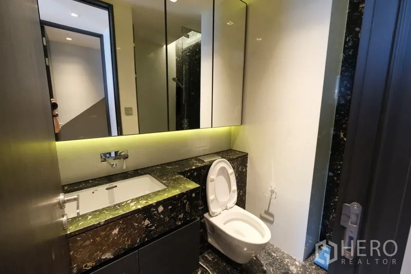 公寓 出租 - 客卫配大理石台面、背光镜柜与挂墙式马桶。