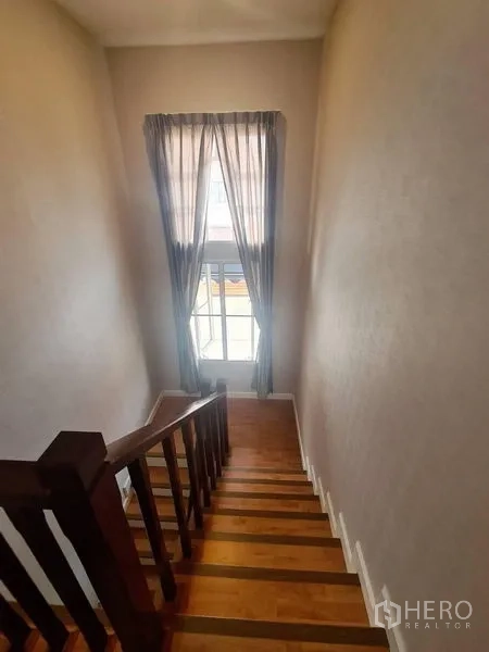 บ้าน ให้เช่าในSai Mai, Bangkok - บันไดไม้พร้อมหน้าต่างสูงและผ้าม่านโปร่ง
