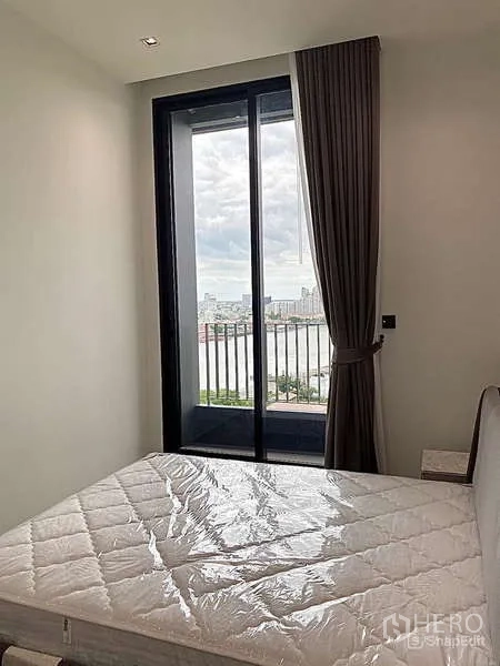 คอนโด ให้เช่า - ห้องนอนติดระเบียง หน้าต่างสูงจากพื้นจรดเพดาน มองเห็นวิวแม่น้ำเจ้าพระยา