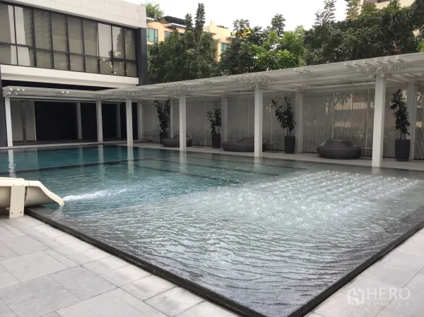 Condominium for rent in Pathum Wan, Bangkok - Resort-style swimming pool with bubble-jet shallow area and shaded lounge seats.