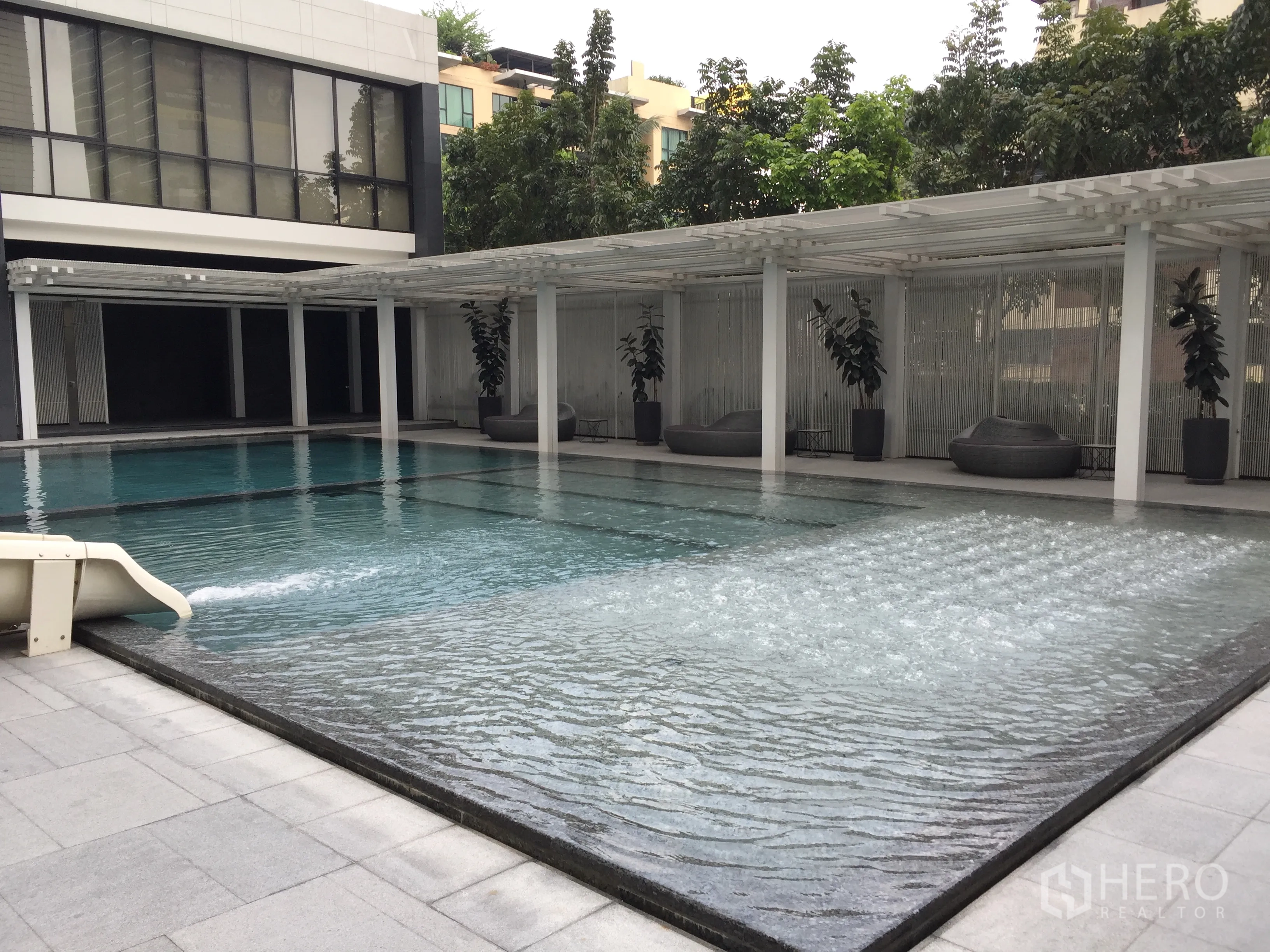 Condominium for rent in Pathum Wan, Bangkok - Resort-style swimming pool with bubble-jet shallow area and shaded lounge seats.